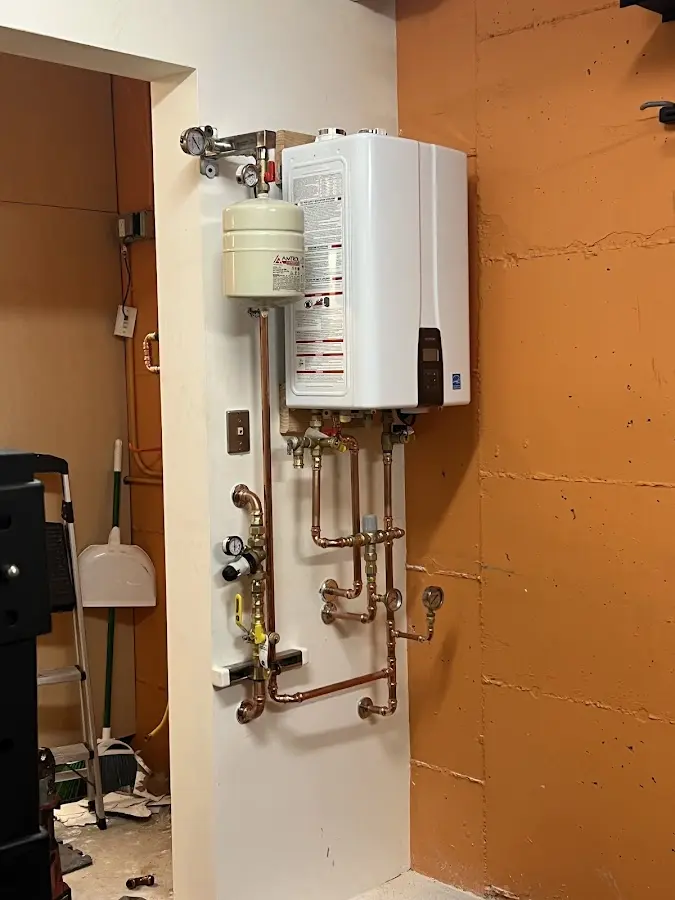 Plumbing technician inspecting water heater connections in Elk Grove Village